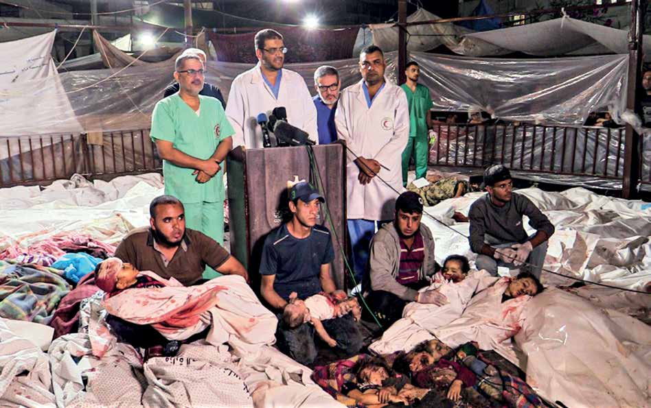 Doctors from Shifa Hospital hold a brief press conference among the injured and dead brought in following the Israeli army’s attack on the Al-Ahli Arab Baptist Hospital.