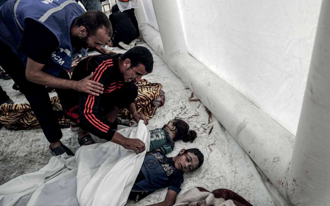 A Palestinian man at Shifa Hospital bids a heart-wrenching farewell to his children, victims of the Israeli army’s attacks.