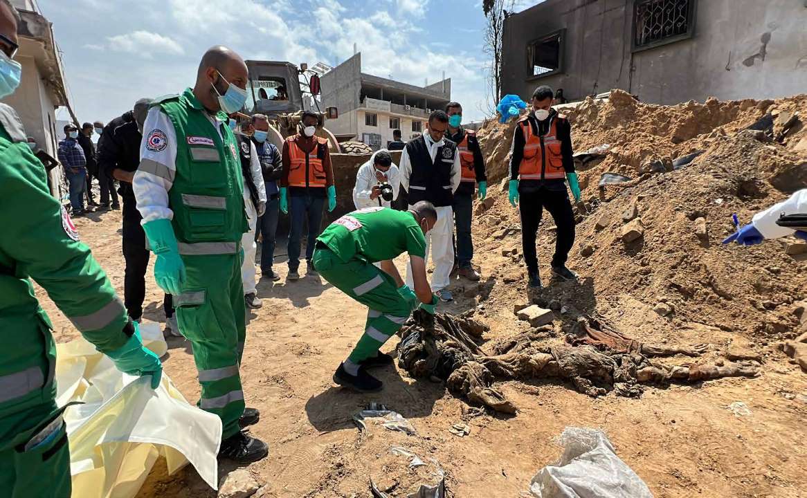 Government-affiliated health, civil defense, crime scene investigation, and forensic teams in Gaza are collecting the decayed bodies of Palestinians killed during Israeli forces' 14-day assault, which began on March 18. The assault left Al-Shifa Hospital and its surrounding areas completely unusable. The teams are working to identify the victims.