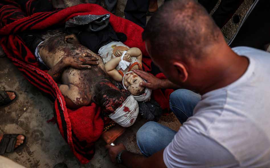 The bodies of 2-year-old Jamal Elsayed (right) and his father (left), who were killed in an Israeli military strike on a home in the Al-Bureij Refugee Camp in central Gaza, were brought to the morgue at the Al- Aqsa Martyrs Hospital in Deir al-Balah.