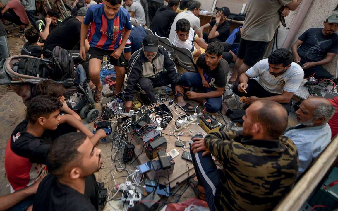 Due to damage to the infrastructure caused by the Israeli army’s airstrikes, Palestinians use car batteries and solar-powered portable charging stations to charge their phones.