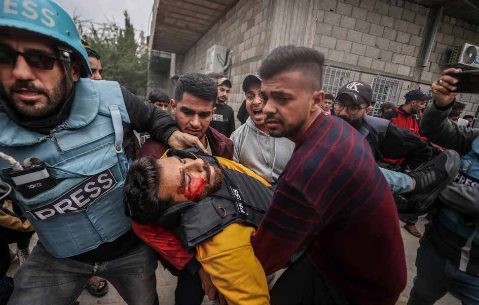 Al Jazeera correspondent Talal Al-Aruki, wounded in an Israeli attack, is being rushed to al-Awda Hospital by fellow journalists. Among those carrying him is AA cameraman Saed Abu Nabhan (second from left), who will later be killed by an Israeli sniper on January 10, 2025.