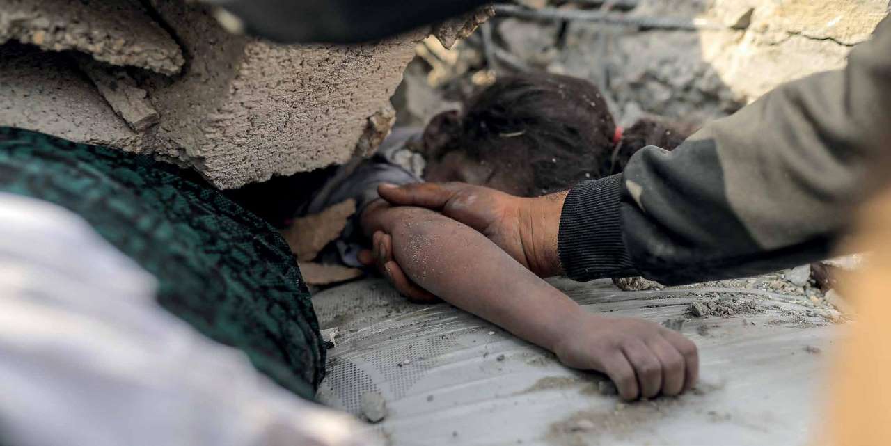 Following the Israel army's airstrikes in Gaza, a rescue worker recovers the lifeless body of a young girl from the rubble.