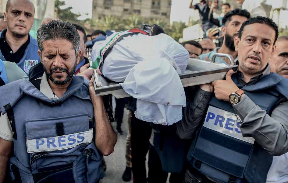 On November 3, 2023, a funeral was held for Palestinian TV journalist Muhammad Abu Hatab, who lost his life along with 10 members of his family in an airstrike on his home in Khan Yunis, Gaza. Hatab's colleagues are somberly carrying his body in grief.