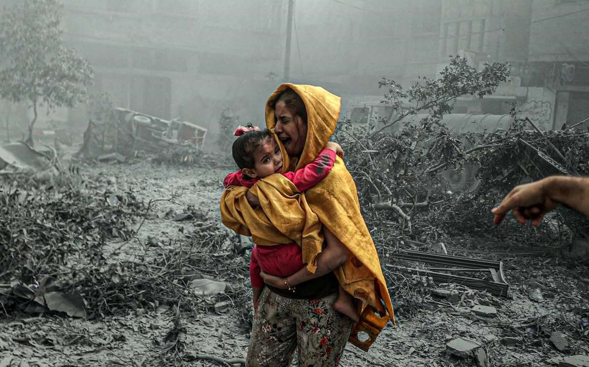 In the aftermath of an Israeli army attack on the Radwan neighborhood in Gaza City, rescue efforts are immediately underway to save those trapped under the debris. A mother, carrying her young daughter, is trying to figure out what to do as she reels from the shock of the explosions.