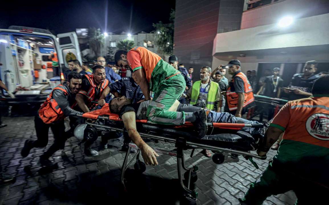 Emergency service and civil defense teams heading to areas under bombardment were targeted by the Israeli army's planes on Al-Jala Street. A heavily wounded civil defense officer receives chest compressions on a stretcher as he is taken inside the Al-Shifa Hospital.