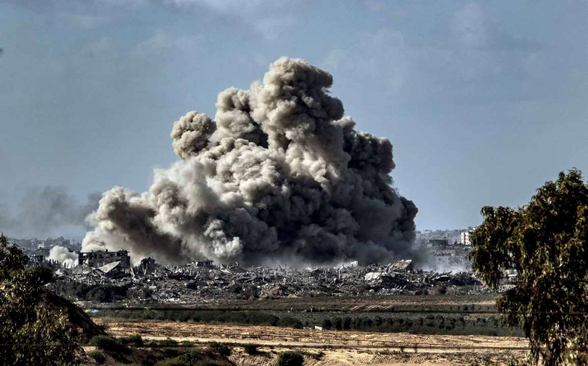 Plumes of smoke drift over the ruins of buildings in Beit Hanoun, Gaza, following Israeli army airstrikes on November 21, 2023, as viewed from Sderot, Israel.